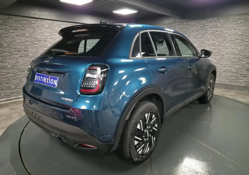 Vue 3/4 arrière droite d'une FIAT 600 Hybrid 2024 bleu métallisé avec feux arrière LED et jantes bicolores.