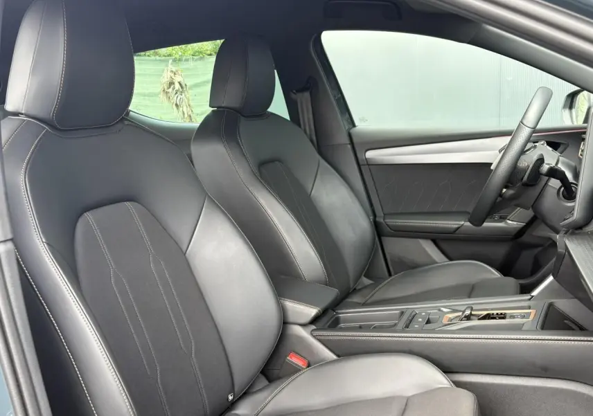 Vue intérieure côté droit montrant les sièges sports bimatière noirs et la console centrale d'une CUPRA Leon 2025.