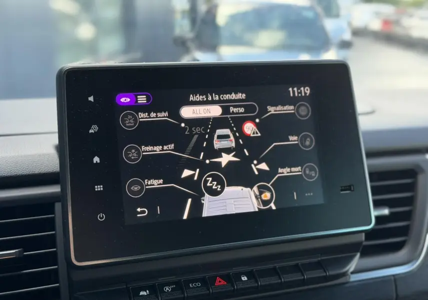 Écran tactile intérieur du Nissan Primastar Combi affichant les aides à la conduite, vu de face.