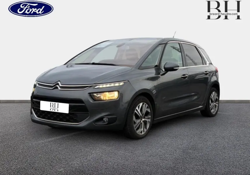 Citroën C4 Picasso gris Shark vue 3/4 avant droit avec phares allumés sur fond neutre.