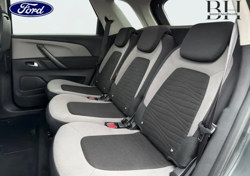 Vue latérale des trois sièges individuels arrière gris et noirs du Citroën C4 Picasso, avec ceintures de sécurité visibles.