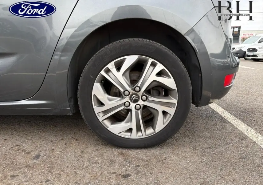Gros plan sur la roue arrière droite avec jante alu gris argent du Citroën C4 Picasso gris Shark.