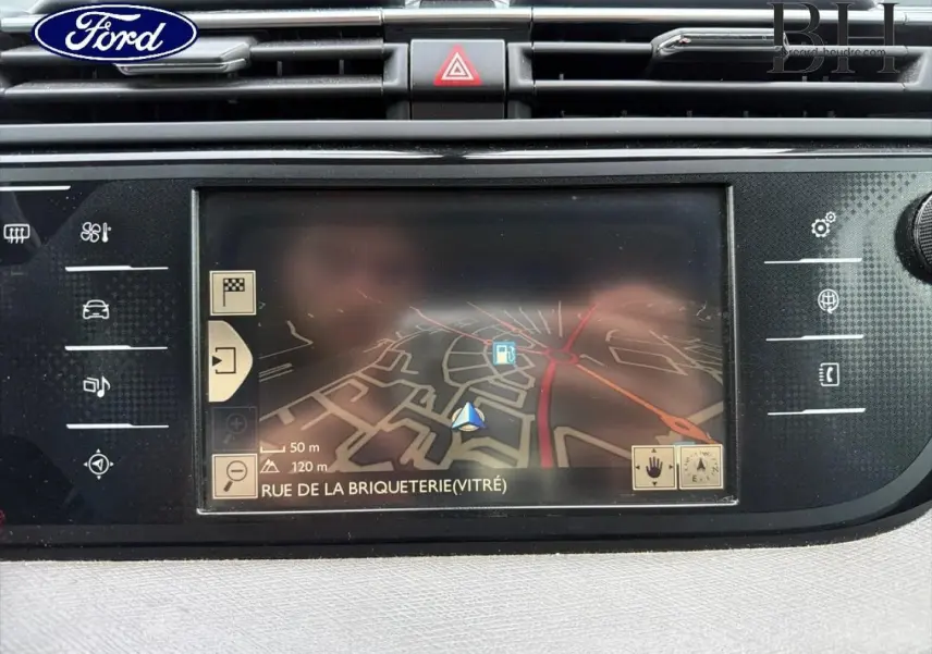 Écran tactile de navigation GPS Ford en gros plan avec carte affichant Rue de la Briqueterie, intérieur noir.