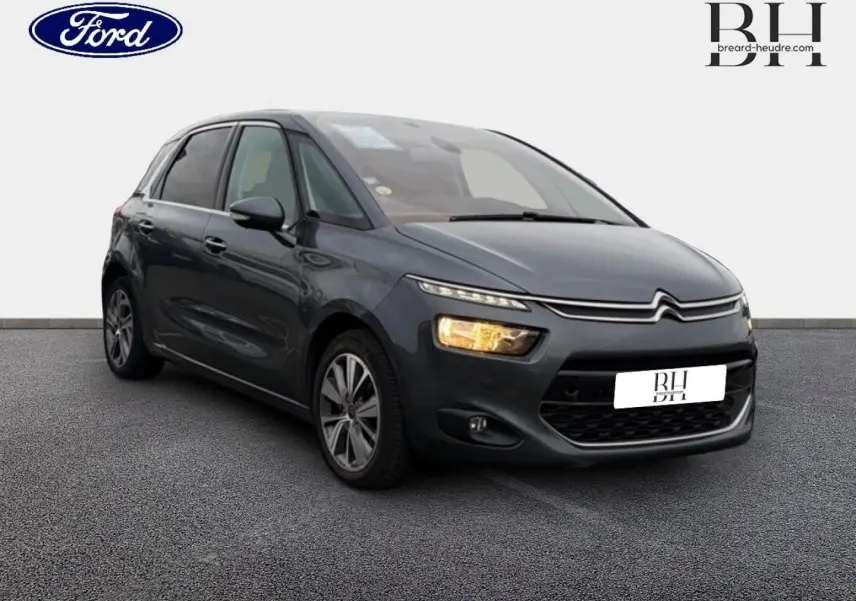 Citroën C4 Picasso gris Shark vue 3/4 avant droit avec feux allumés sur fond neutre.