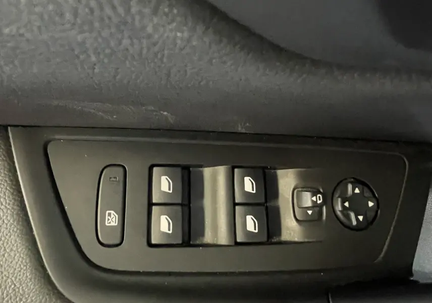 Panneau de commandes des vitres électriques et réglage des rétroviseurs côté conducteur d'une Peugeot 508 gris platinium.