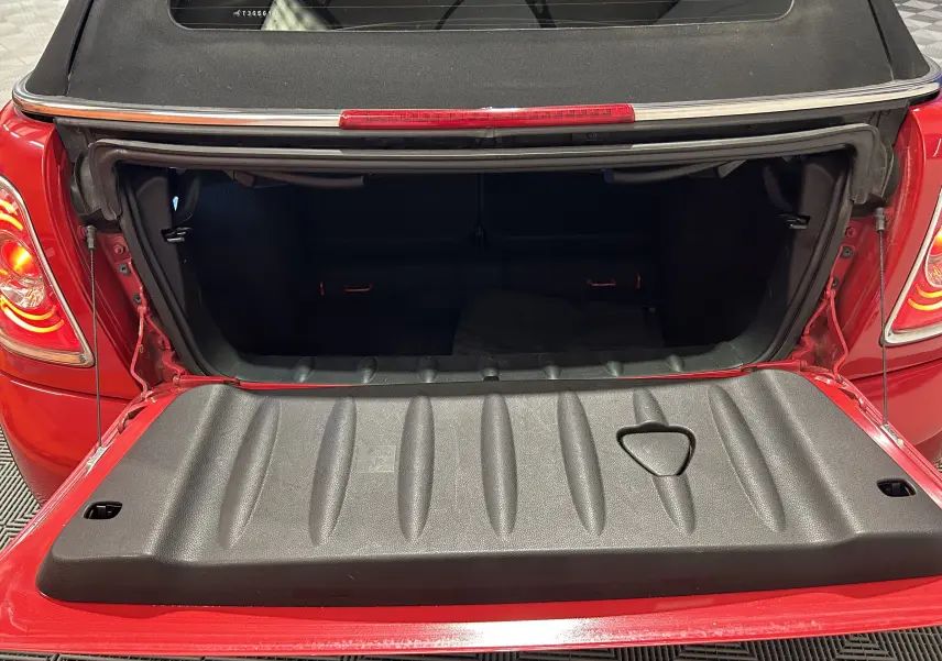 Gros plan sur la double sortie d'échappement arrière d'une MINI Cabriolet Cooper S rouge, avec pare-chocs noir.