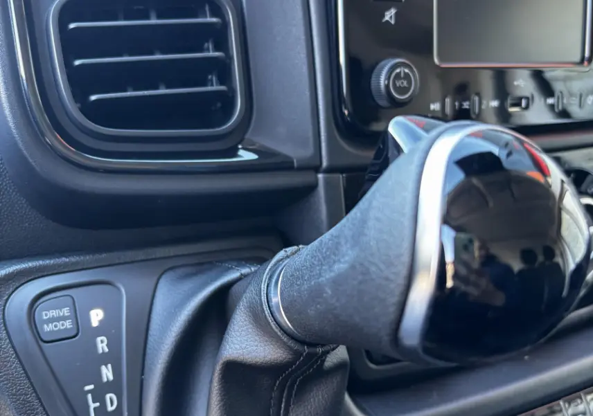 Gros plan sur le levier de vitesses automatique et la console centrale noire du Peugeot Boxer Fourgon blanc, version 2025.