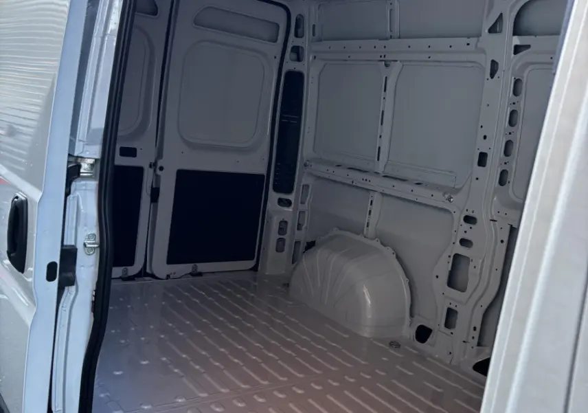 Intérieur du coffre blanc du Peugeot Boxer Fourgon L2H2 2025, vue depuis l'ouverture latérale droite.
