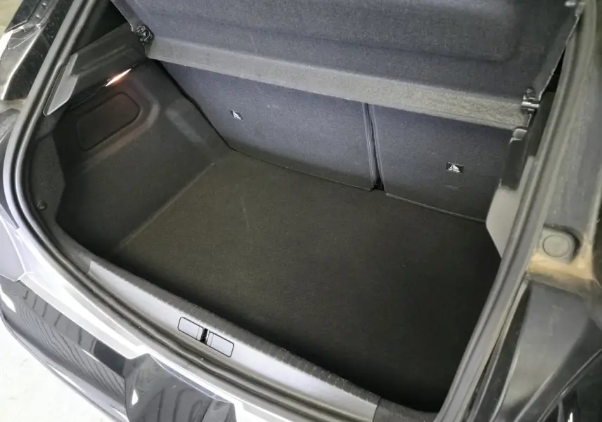 Coffre ouvert vu de dessus d'une Lancia Ypsilon 1.2 Ibrida gris métallisé avec intérieur noir.