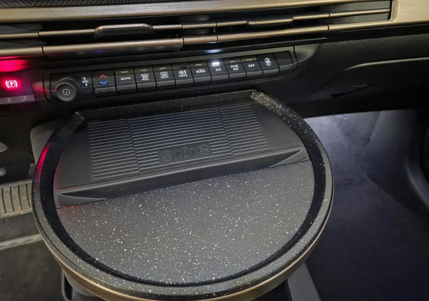 Détail de la console centrale de la Lancia Ypsilon 2025 avec chargeur à induction et commandes climatisation.