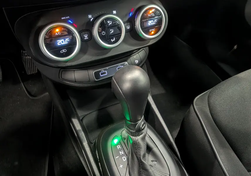 Gros plan sur la console centrale du Fiat 500X noir, montrant la commande de boîte auto et les réglages climatisation à 20°C.
