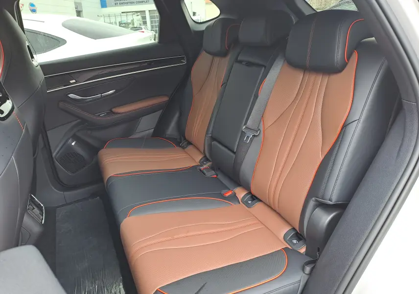 Vue latérale droite des sièges arrière bicolores marron et noir avec surpiqûres orange du BYD SEAL U 2025.