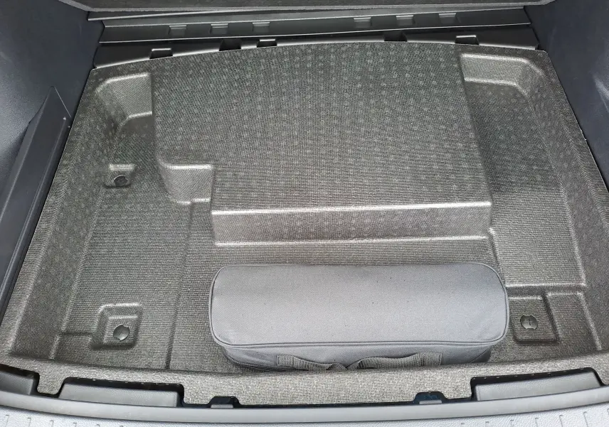 Coffre ouvert vu de dessus du BYD SEAL U 2025, compartiment de rangement gris avec trousse noire.