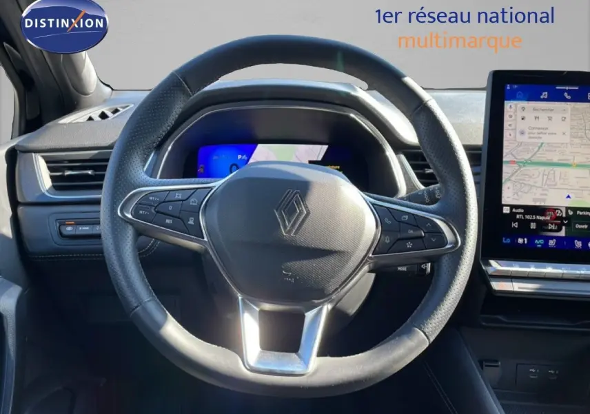 Vue intérieure centrée sur le volant noir perforé du Renault Symbioz 2025 avec tableau de bord numérique et écran tactile GPS.