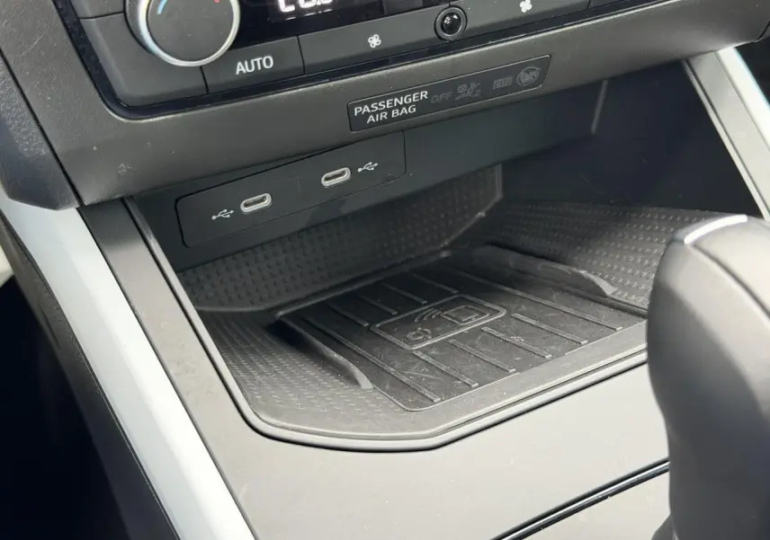 Gros plan sur la console centrale du SEAT Arona blanc, montrant la zone de recharge sans fil et ports USB-C.