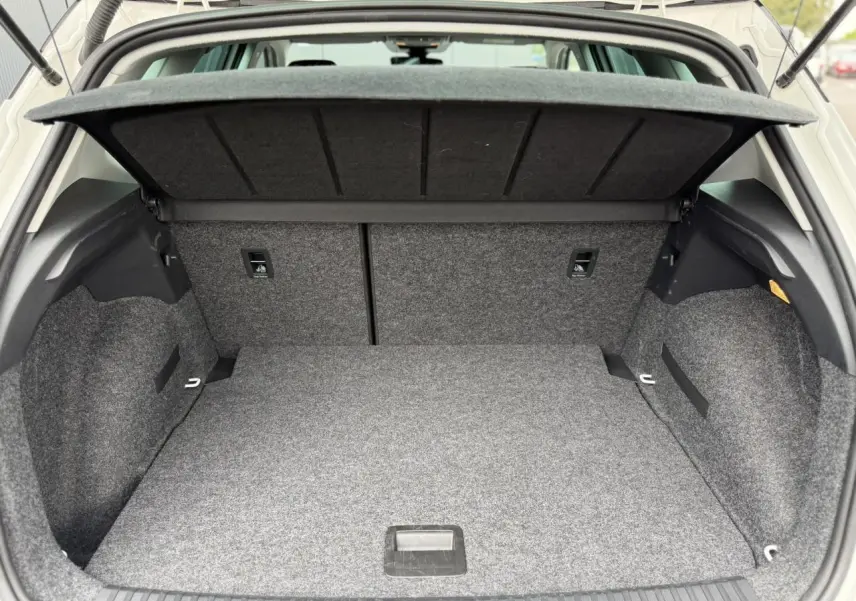 Coffre ouvert vu de l'arrière d'un SEAT Arona blanc, montrant l'espace de rangement et la couverture de coffre.