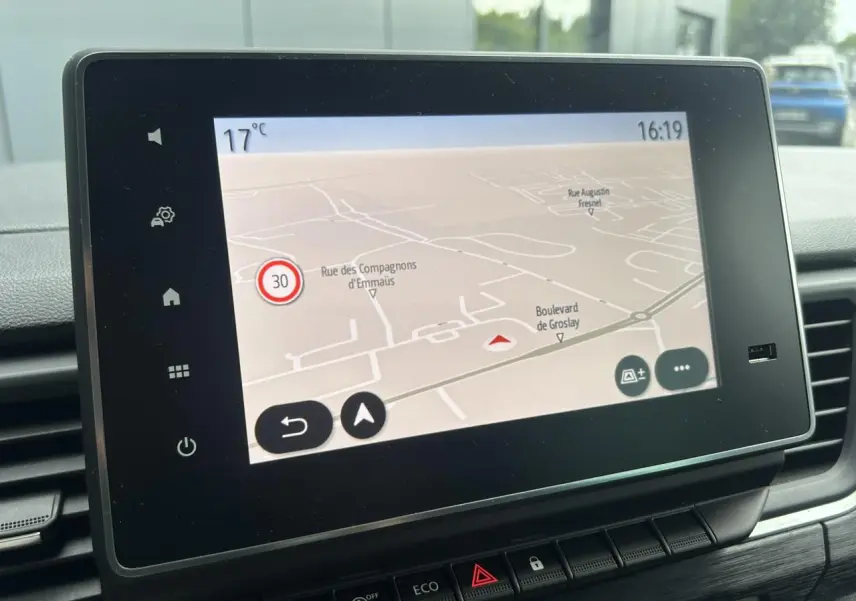 Écran tactile central affichant la navigation GPS dans l'habitacle du Nissan Primastar gris Highland, vue de face rapprochée.