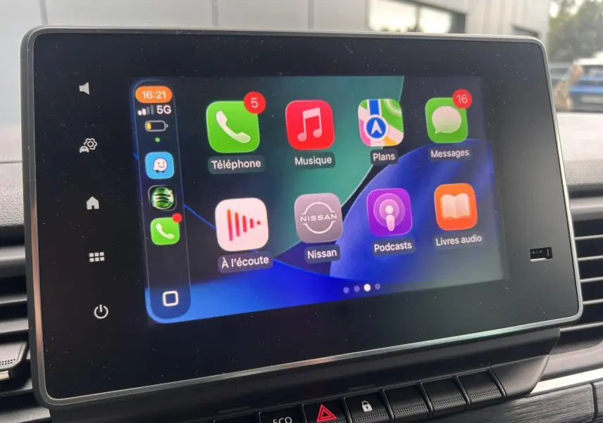 Écran tactile central affichant l'interface Apple CarPlay dans l'habitacle d'un Nissan Primastar gris Highland.