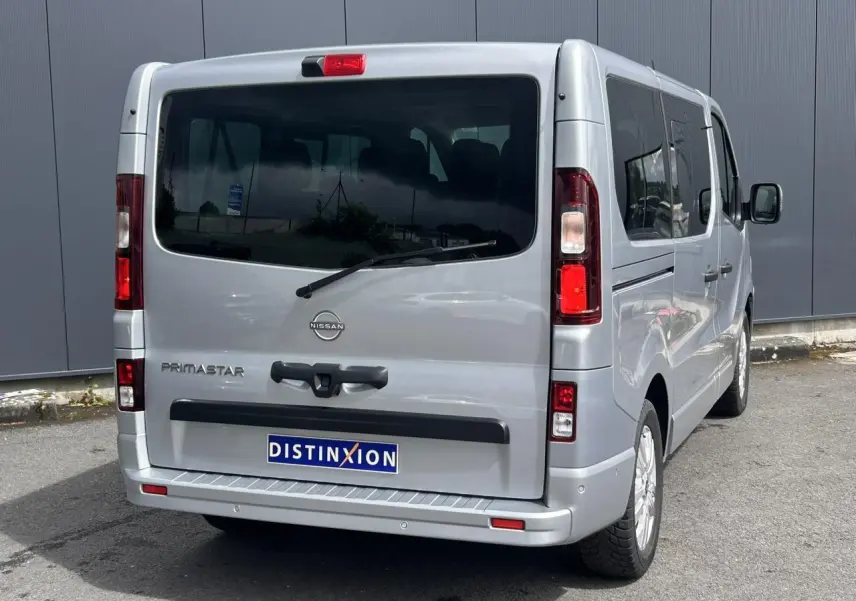 Vue 3/4 arrière droite du Nissan Primastar gris Highland avec hayon vitré et vitres latérales teintées.
