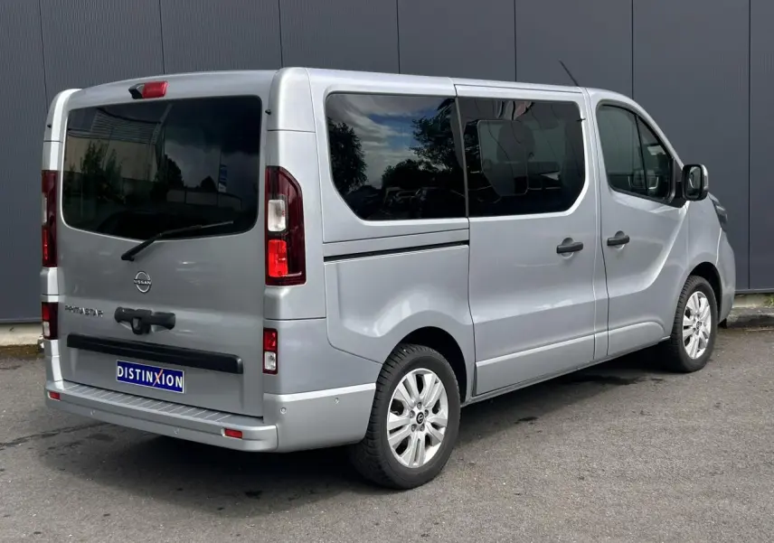 Vue 3/4 arrière droite du Nissan Primastar gris Highland avec hayon vitré et vitres surteintées.