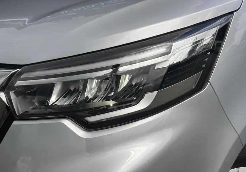 Gros plan sur le phare avant droit du Nissan Primastar gris Highland, mettant en valeur son design LED moderne.