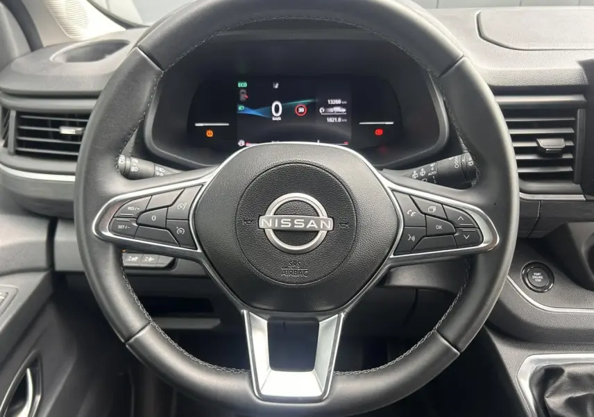 Vue centrée sur le volant noir du Nissan Primastar 2025 avec tableau de bord numérique et bouton démarrage sans clé.