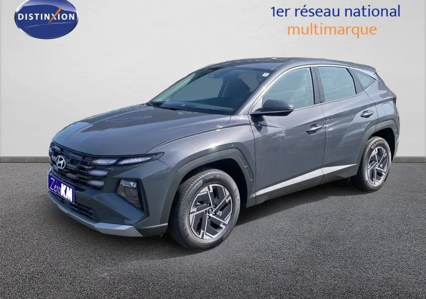 Hyundai Tucson gris Ecotronic Metal en 3/4 avant droit, SUV hybride avec jantes bi-ton et calandre marquée.