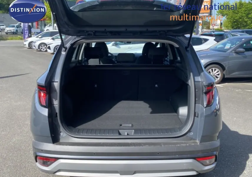 Vue arrière du Hyundai Tucson gris Ecotronic Metal 2026 avec coffre ouvert montrant l'espace de chargement vide.