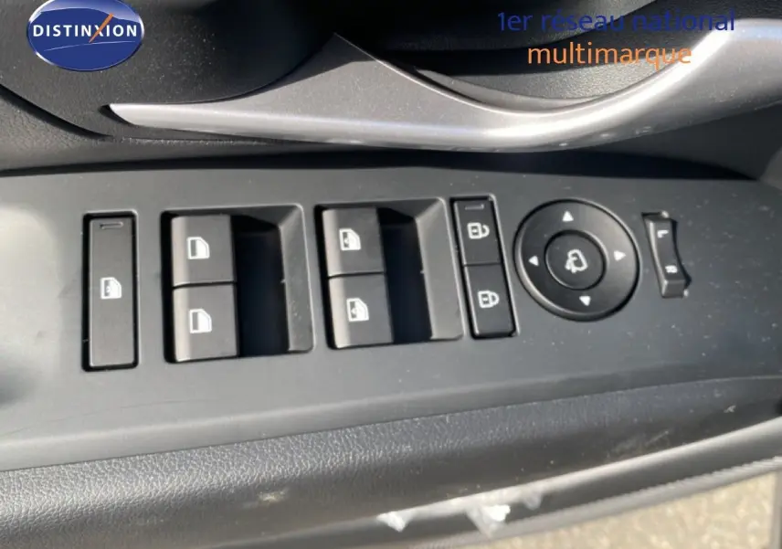 Gros plan sur les commandes de lève-vitres et rétroviseurs côté conducteur du Hyundai Tucson gris Ecotronic 2026.