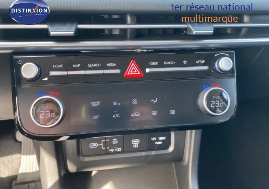 Vue rapprochée de la console centrale du Hyundai Tucson gris Ecotronic, affichant la climatisation digitale à 23°C.