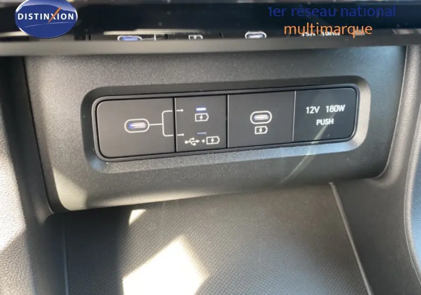 Gros plan sur les ports USB et prise 12V du Hyundai Tucson gris Ecotronic Metal, intérieur noir.