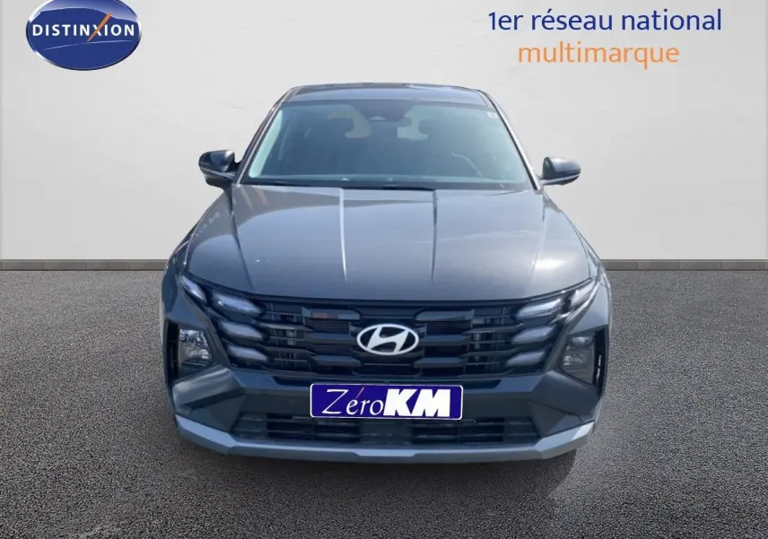 Vue frontale d'un Hyundai Tucson gris Ecotronic Metal avec calandre noire et phares LED intégrés.