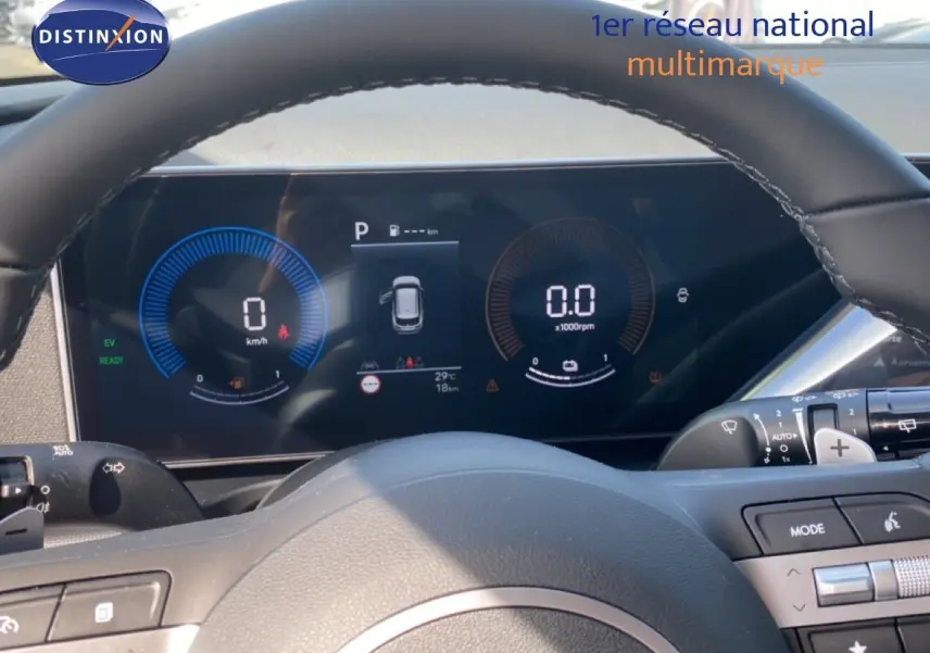 Vue rapprochée du tableau de bord numérique et volant cuir noir du Hyundai Tucson gris Ecotronic 2026 hybride essence.