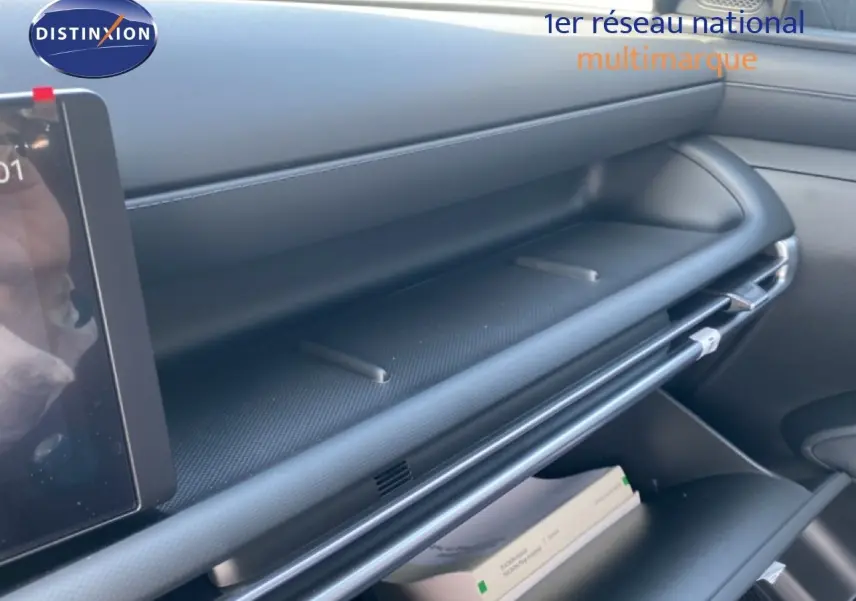 Intérieur du Hyundai Tucson 2026, vue latérale du tableau de bord et rangement ouvert en finition noire moderne.