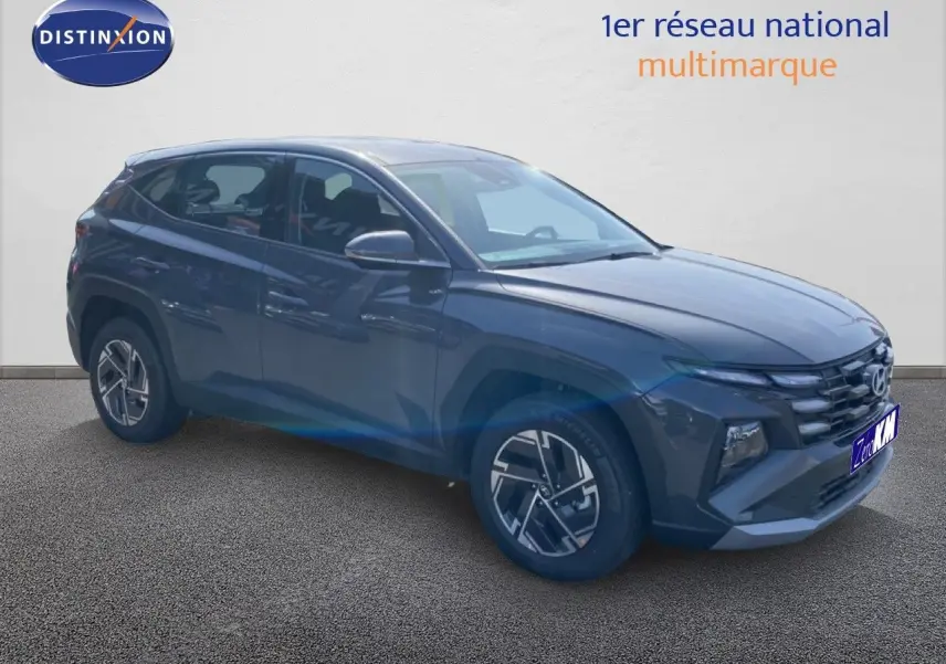 Vue 3/4 avant droite du Hyundai Tucson gris Ecotronic Metal avec jantes alliage et calandre marquée.