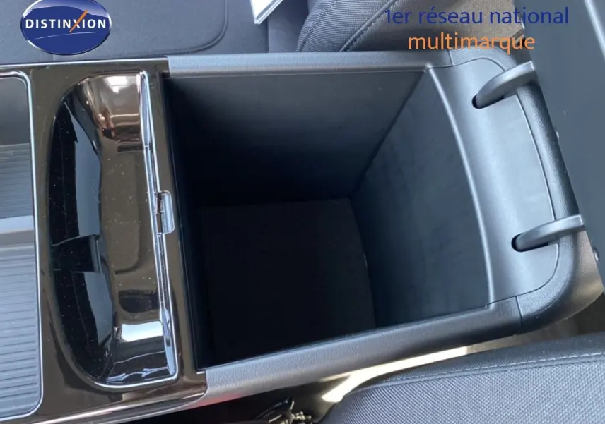 Vue intérieure en gros plan du rangement central ouvert du Hyundai Tucson 2026, avec finition tissu noir visible.