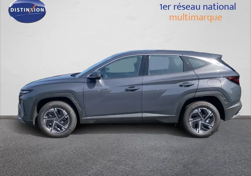 Vue de profil côté gauche d'un Hyundai Tucson gris Ecotronic Metal 2026 avec jantes bi-ton et lignes anguleuses marquées.