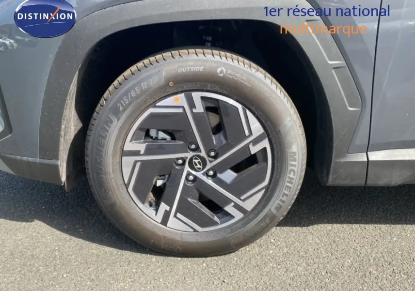 Gros plan sur la roue avant droite du Hyundai Tucson gris Ecotronic Metal avec jante alliage au design moderne.