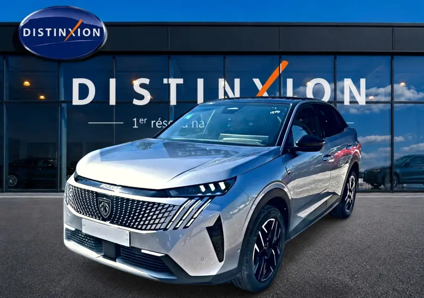 Peugeot 3008 gris 3/4 avant droit, avec calandre distinctive et phares LED, devant une vitrine Distinxion.