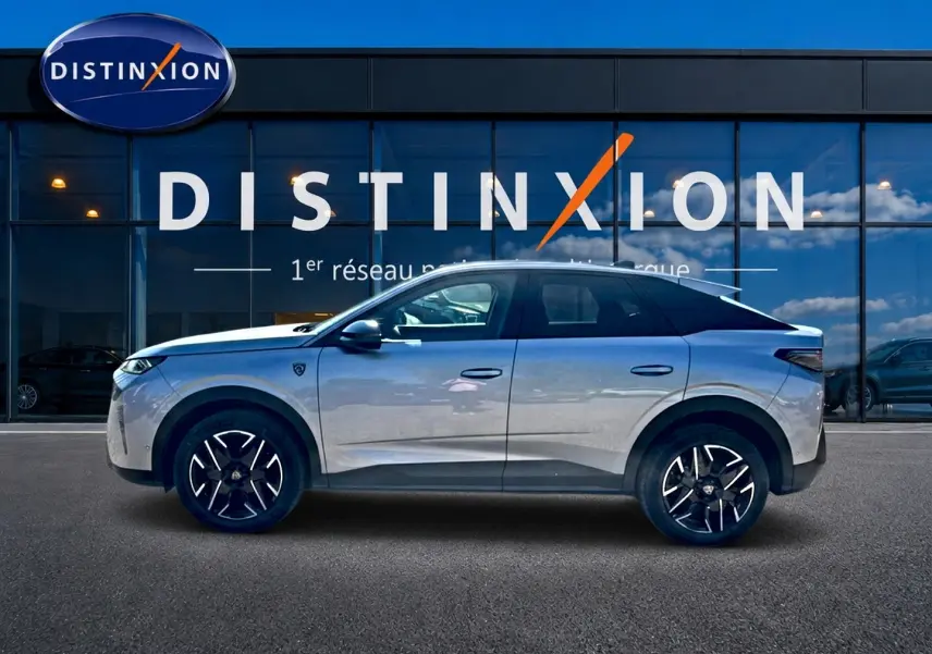 Vue de profil côté gauche d'un Peugeot 3008 gris 2025 garé devant une vitrine avec logo Distinxion.
