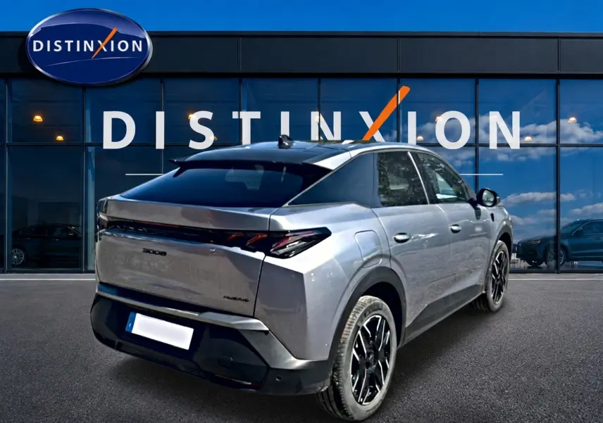 Vue 3/4 arrière droite du Peugeot 3008 gris 2025 avec toit noir et jantes alliage noires devant une vitrine Distinxion.
