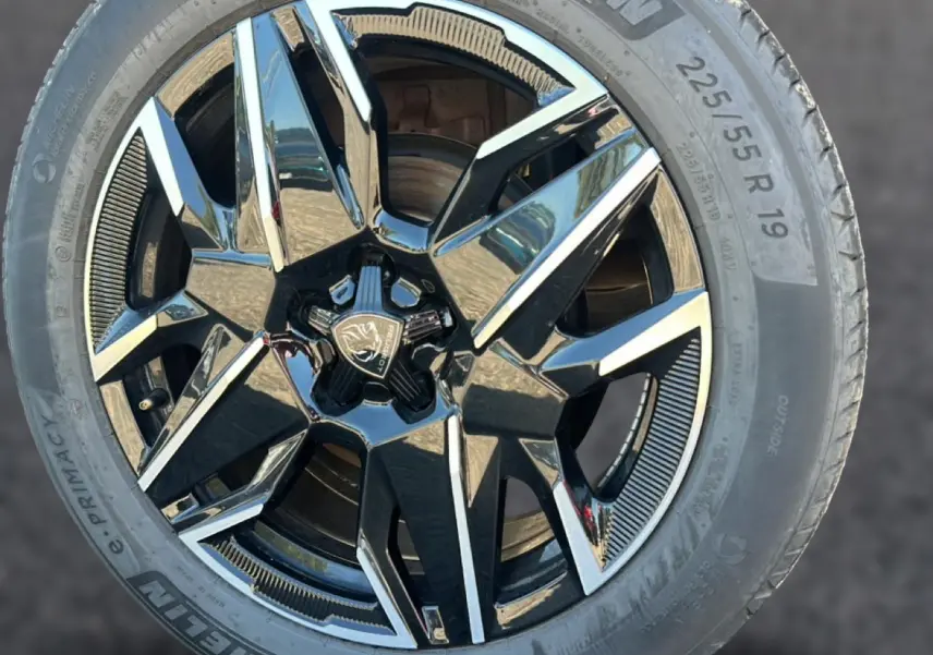 Gros plan sur la jante alu noire et argentée de 19 pouces du Peugeot 3008 gris 1.2 hybrid 145 GT.