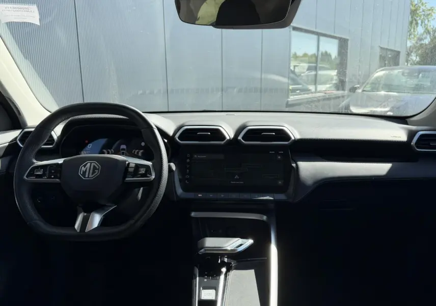 Vue intérieure avant du MG ZS 1.5 Hybrid+ 197 Luxury, tableau de bord noir avec écran tactile et volant multifonction.