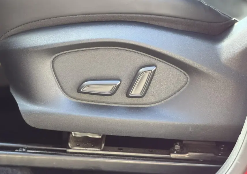 Gros plan sur les commandes électriques de réglage du siège avant côté conducteur du MG ZS 1.5 Hybrid+ 197 Luxury.