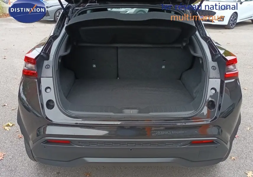 Vue arrière du coffre ouvert d'un Nissan Juke Hybrid 143ch Business+ noir métal, montrant l'espace de chargement vide.