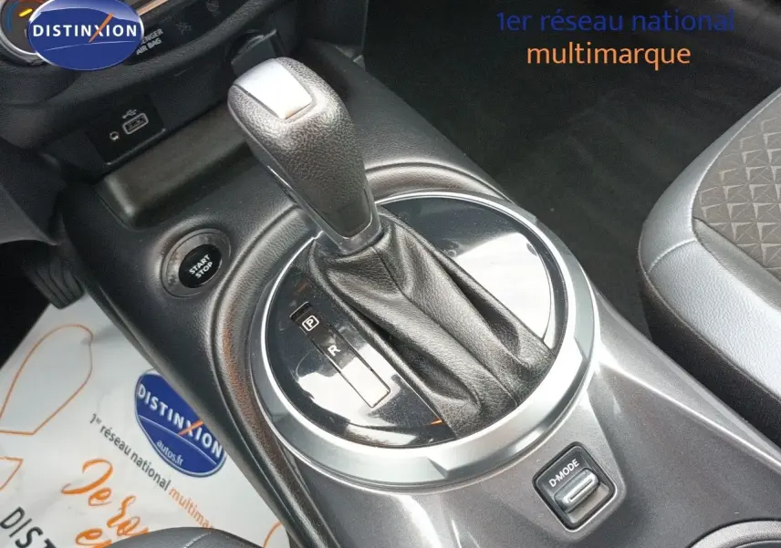Gros plan sur le levier de vitesses automatique du Nissan Juke Hybrid noir métal, avec bouton D-Mode visible.