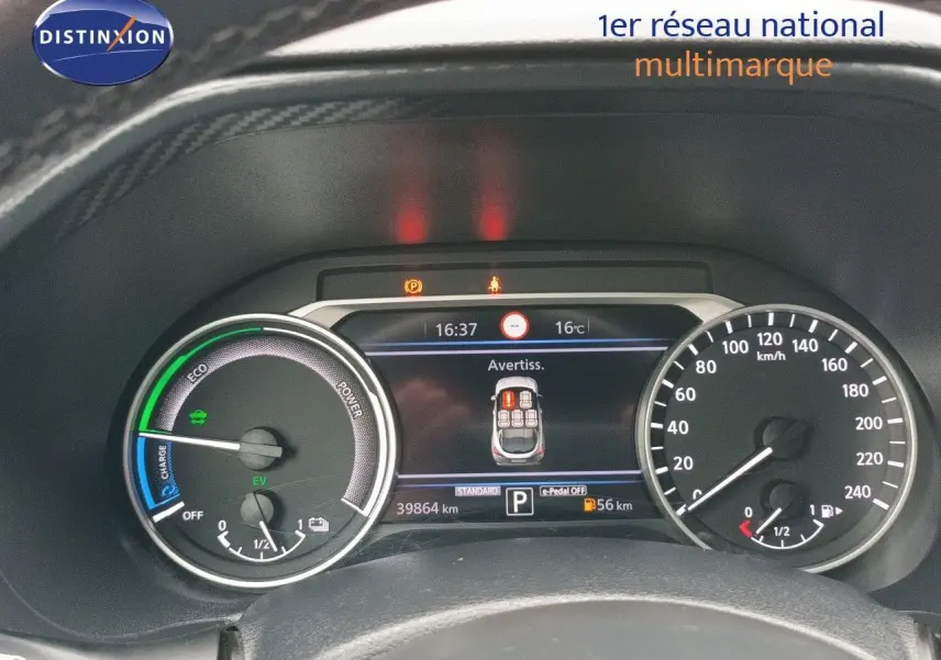 Vue rapprochée du tableau de bord du Nissan Juke Hybrid noir, affichant les compteurs et l'écran digital central.