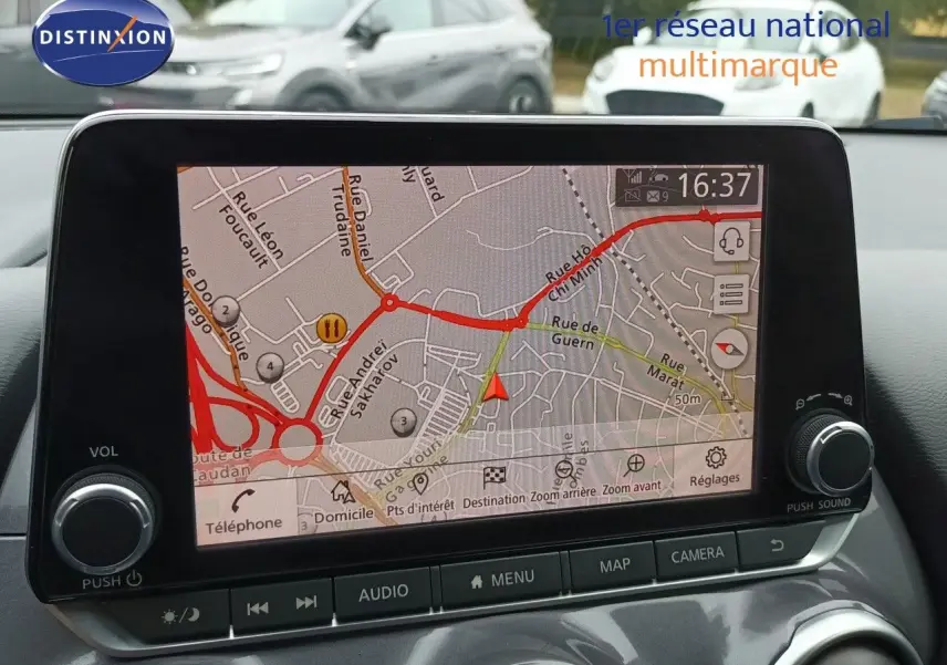 Vue intérieure sur l’écran tactile du GPS du Nissan Juke Hybrid 2024 noir métal, affichant une carte routière détaillée.