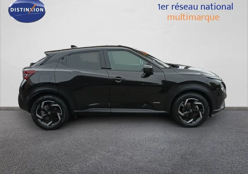 Profil droit du Nissan Juke Hybrid 143ch Business+ 2024 en noir métal avec jantes noires et détails hybrides visibles.