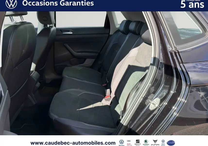 Vue côté droit sur l'intérieur arrière d'une Volkswagen Polo noire intense nacrée avec sièges tissu et alcantara.